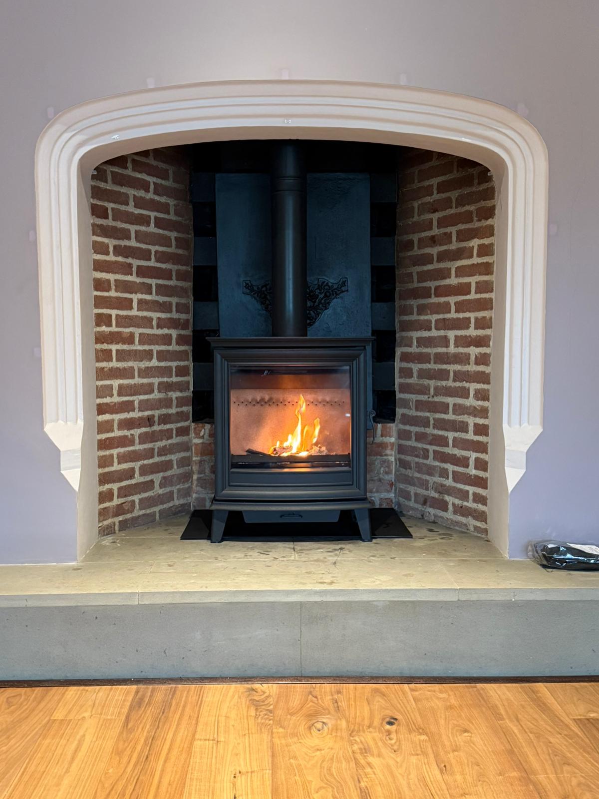 Arched brick fireplace reconstruction with stove