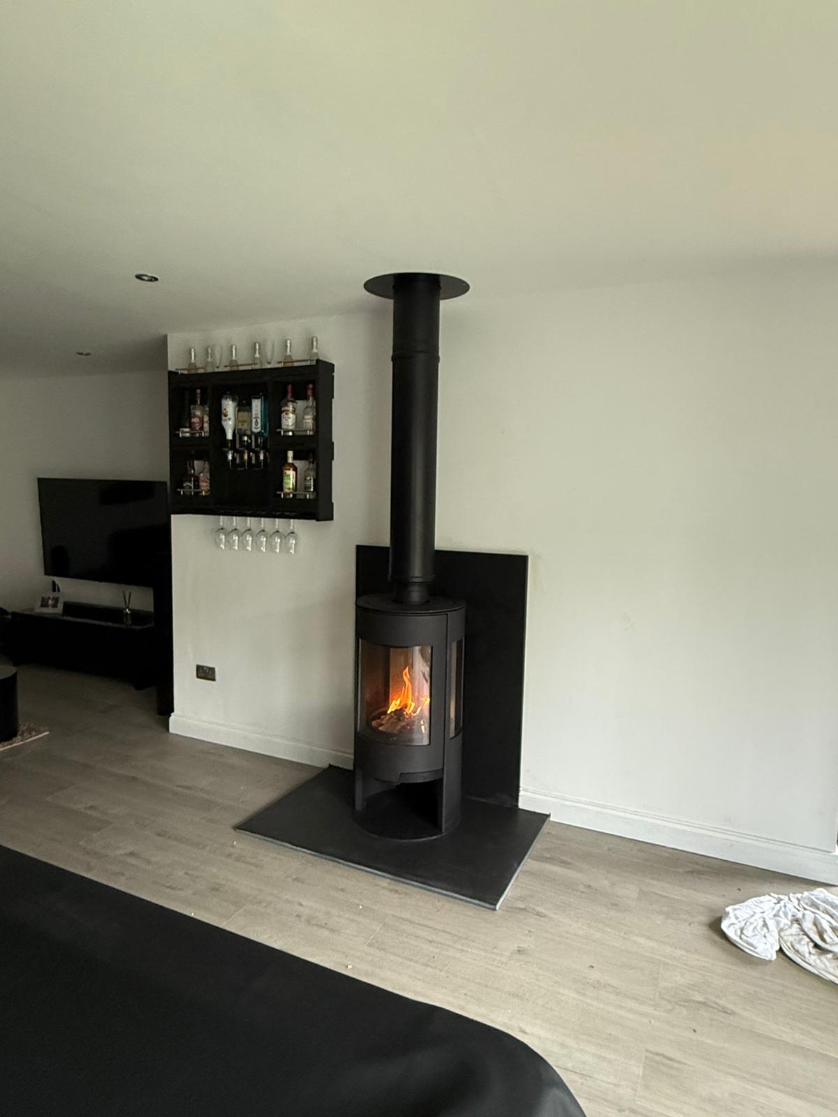 Modern cylindrical wood-burning stove install